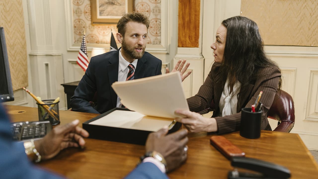 A woman with sheets of paper in her hands and a man